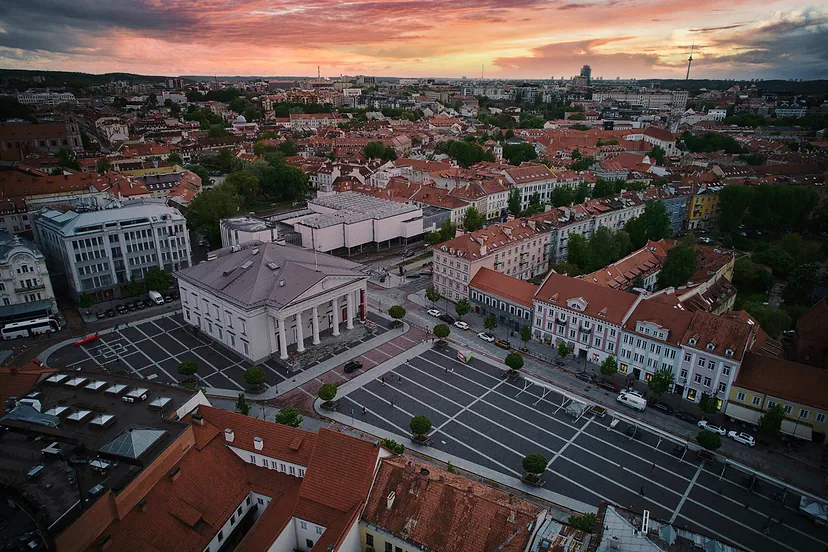 Miesto aikštė, teatras ir senamiesčio stogai saulėlydžio metu iš oro