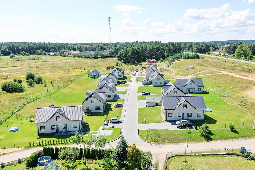 Street of new houses among meadows from the air