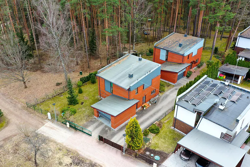 Modern houses with solar panels by the forest from the air