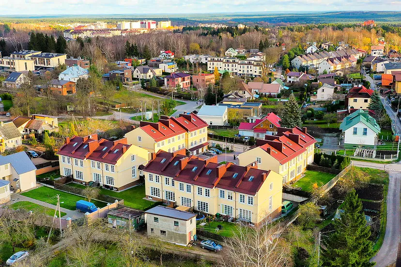 Townhouses with red roofs and the neighborhood in the fall from the air
