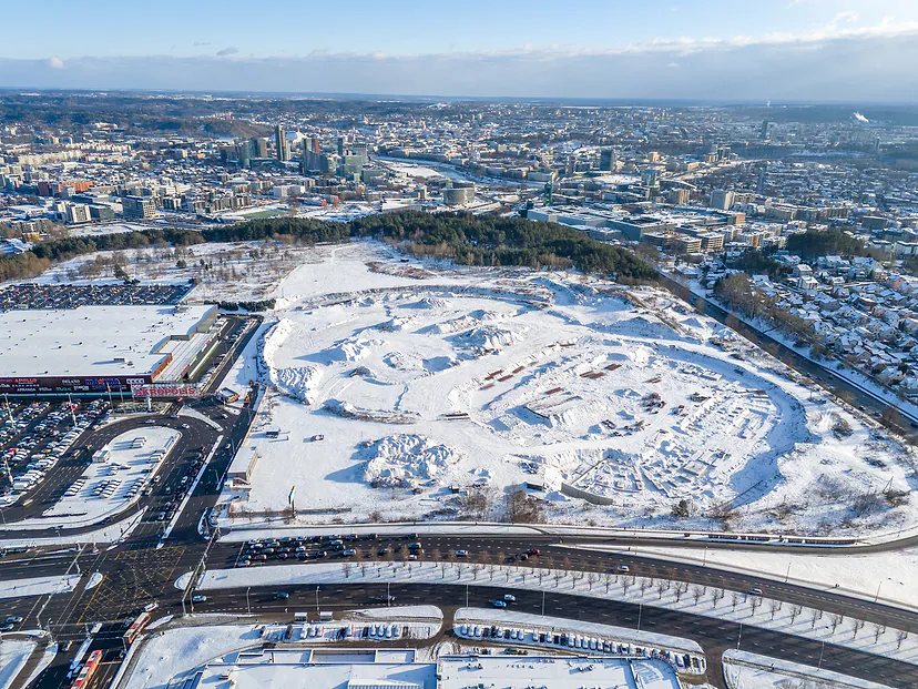 Didelė statybvietė žiemą, fone Vilnius