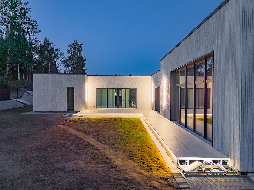 Yard of a modern house with a lit path at dusk