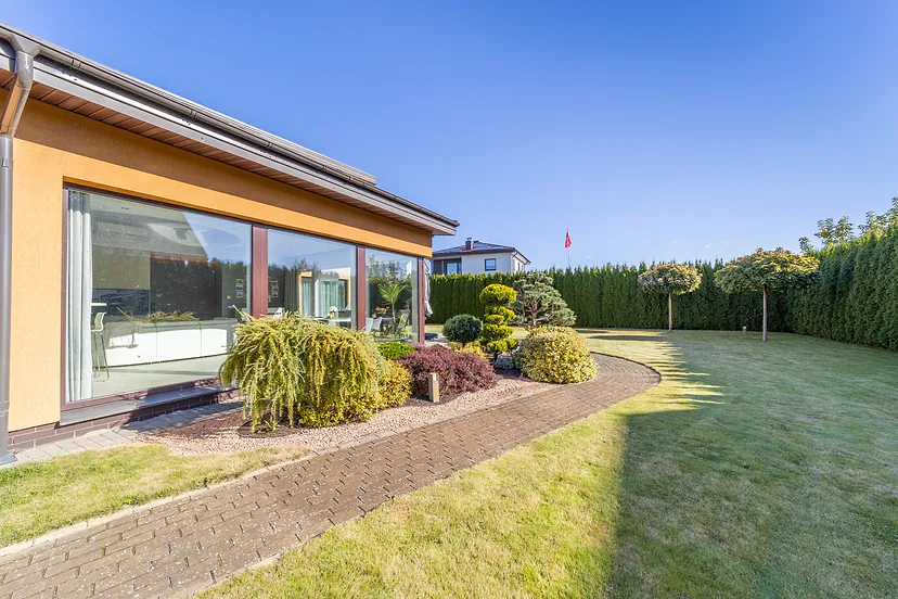 Glass wall of the house and a garden path