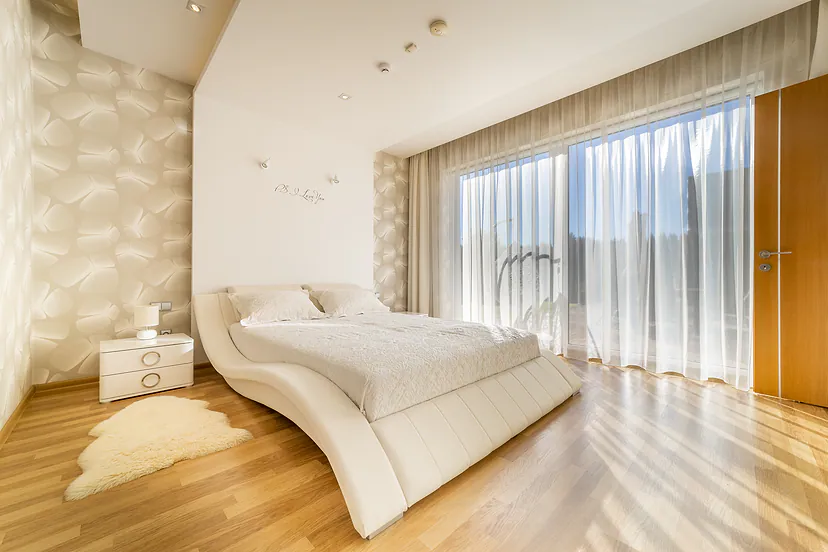 Bedroom with a large bed and a window across the whole wall