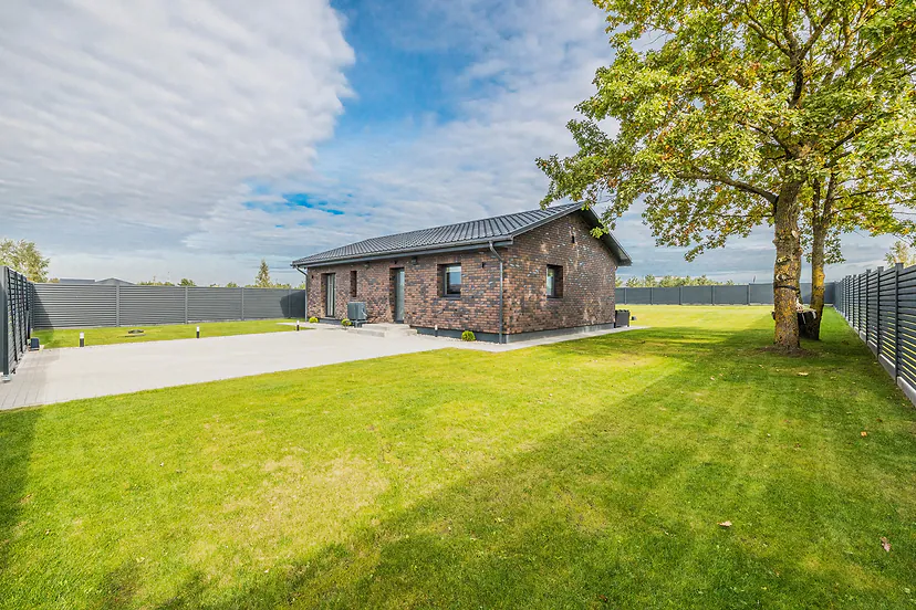 Single-storey brick house with a lawn and a big tree in the yard