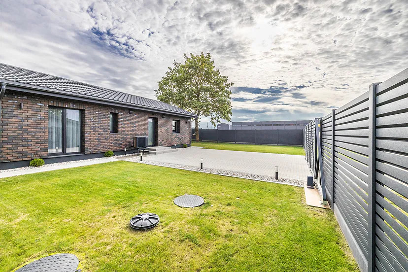 The house and the fenced yard with a lawn