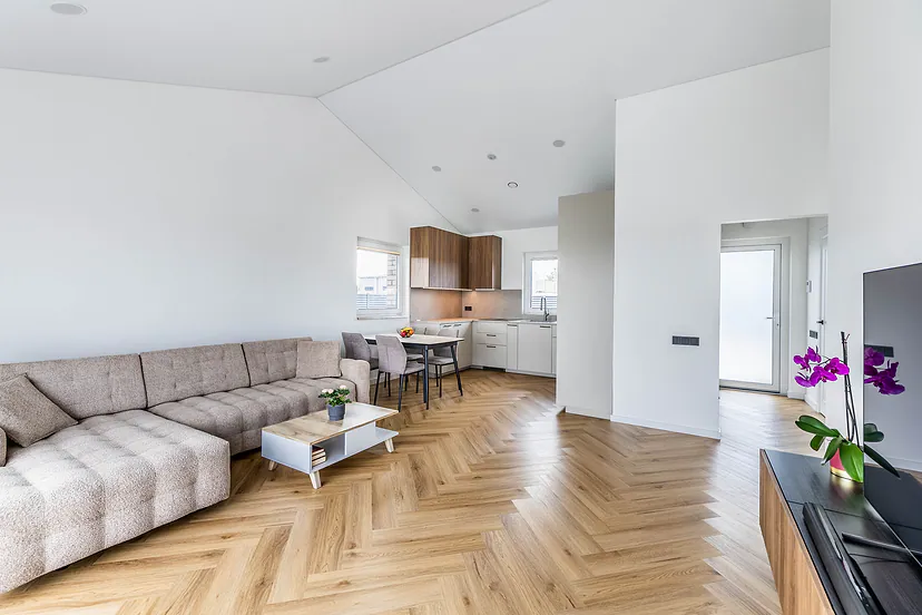 Living room with a corner sofa and the kitchen, herringbone floors
