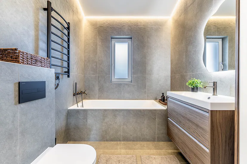Bathroom with a bathtub and a lit mirror