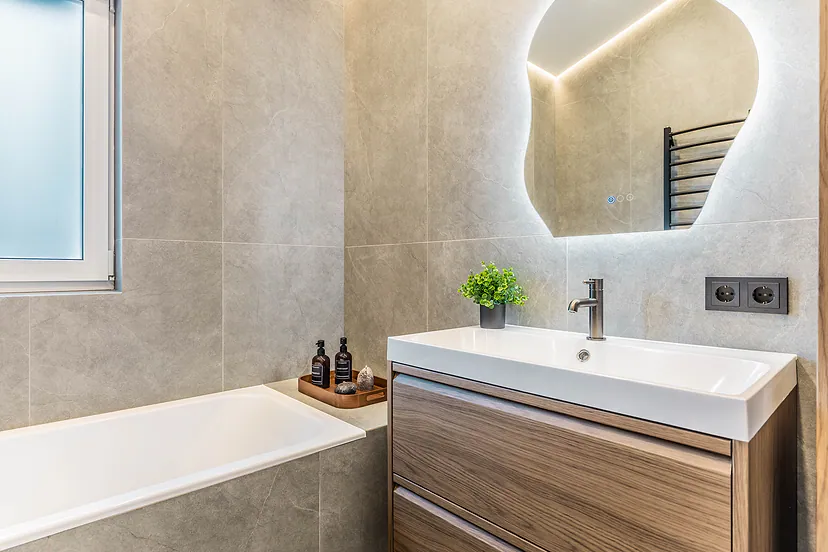 Sink with a wooden vanity unit and an irregular mirror