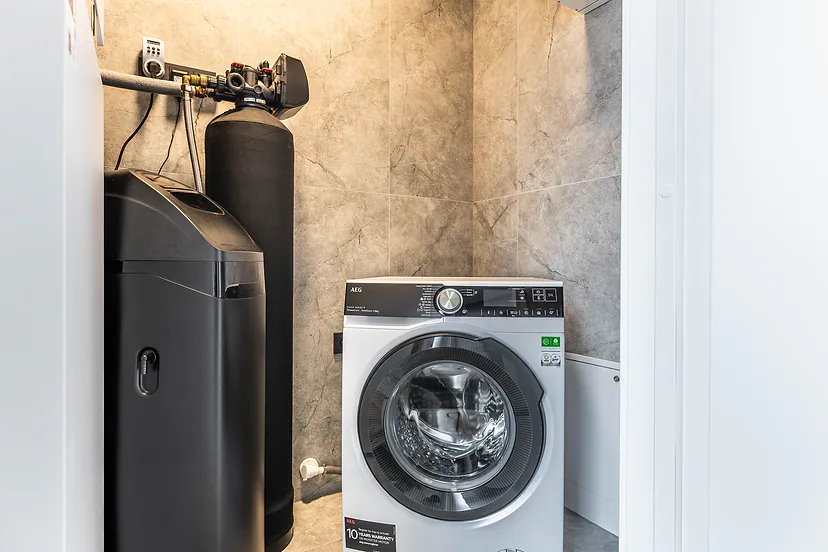 Utility room with a washing machine and a water filter