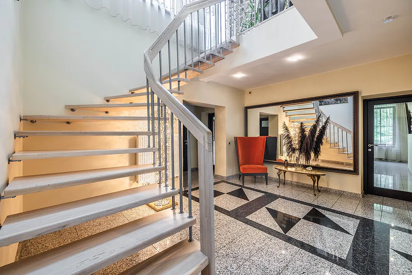 Hall with curved stairs and stone floors