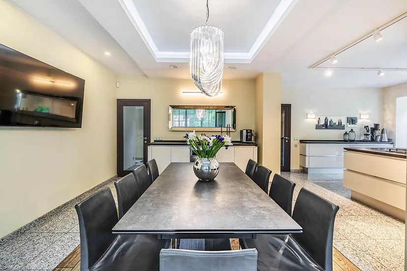 Dining room with a long table next to the kitchen