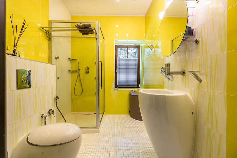 Yellow bathroom with a shower and a freestanding sink