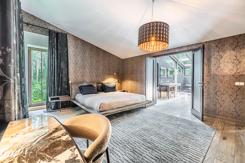 Large bedroom with doors to a glass veranda