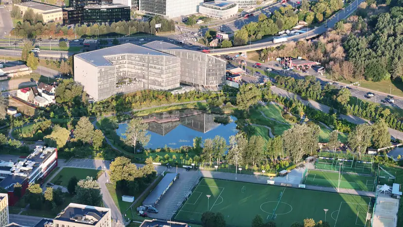 Office building by a pond at sunrise, filmed by drone