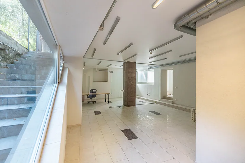 Bright commercial space with glass partitions and tiled floors