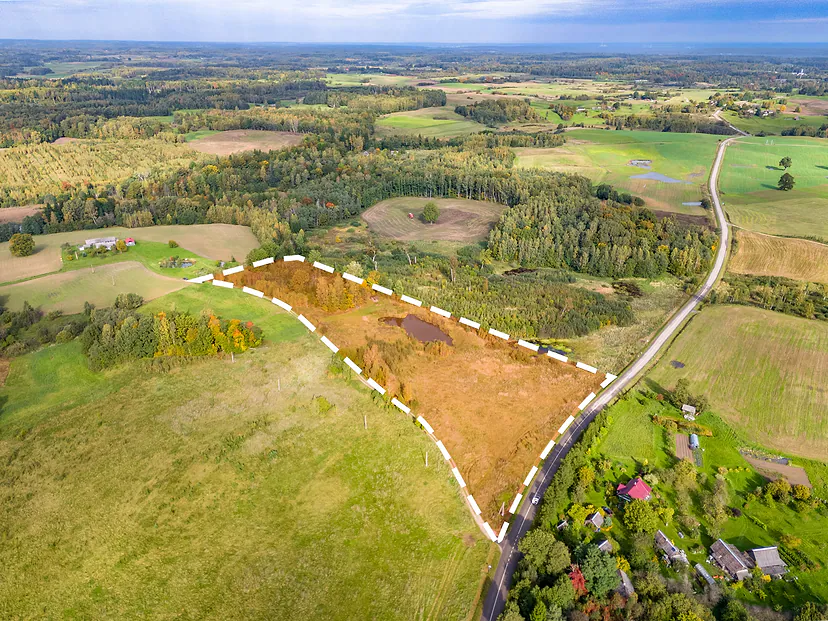 Plot marked in orange with a dashed line, hills and fields around it