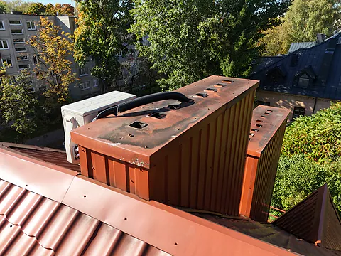 Metal chimney with an air conditioning unit up close, drone inspection