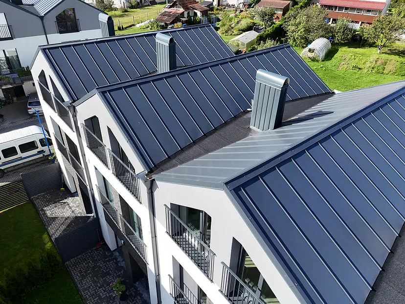 Townhouses with dark metal roofs in the sun