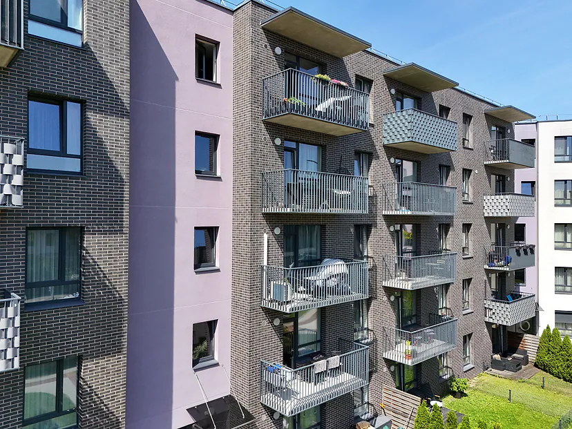Brick apartment facade with balconies on a sunny day