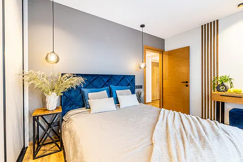 Bedroom with a blue velvet headboard and wooden slats