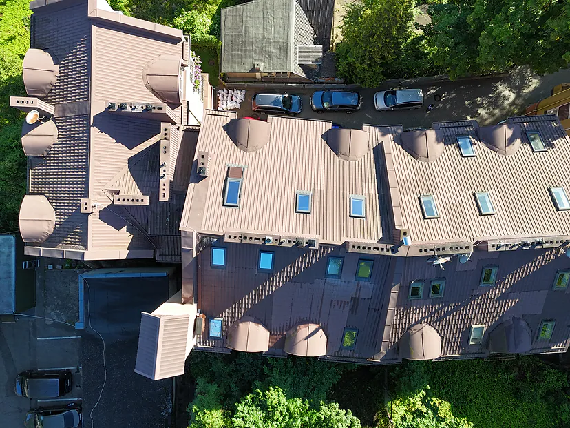 Apartment building roof with skylights and chimneys, view straight from above