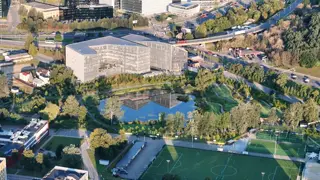 Office building by a pond at sunrise, filmed by drone (2)